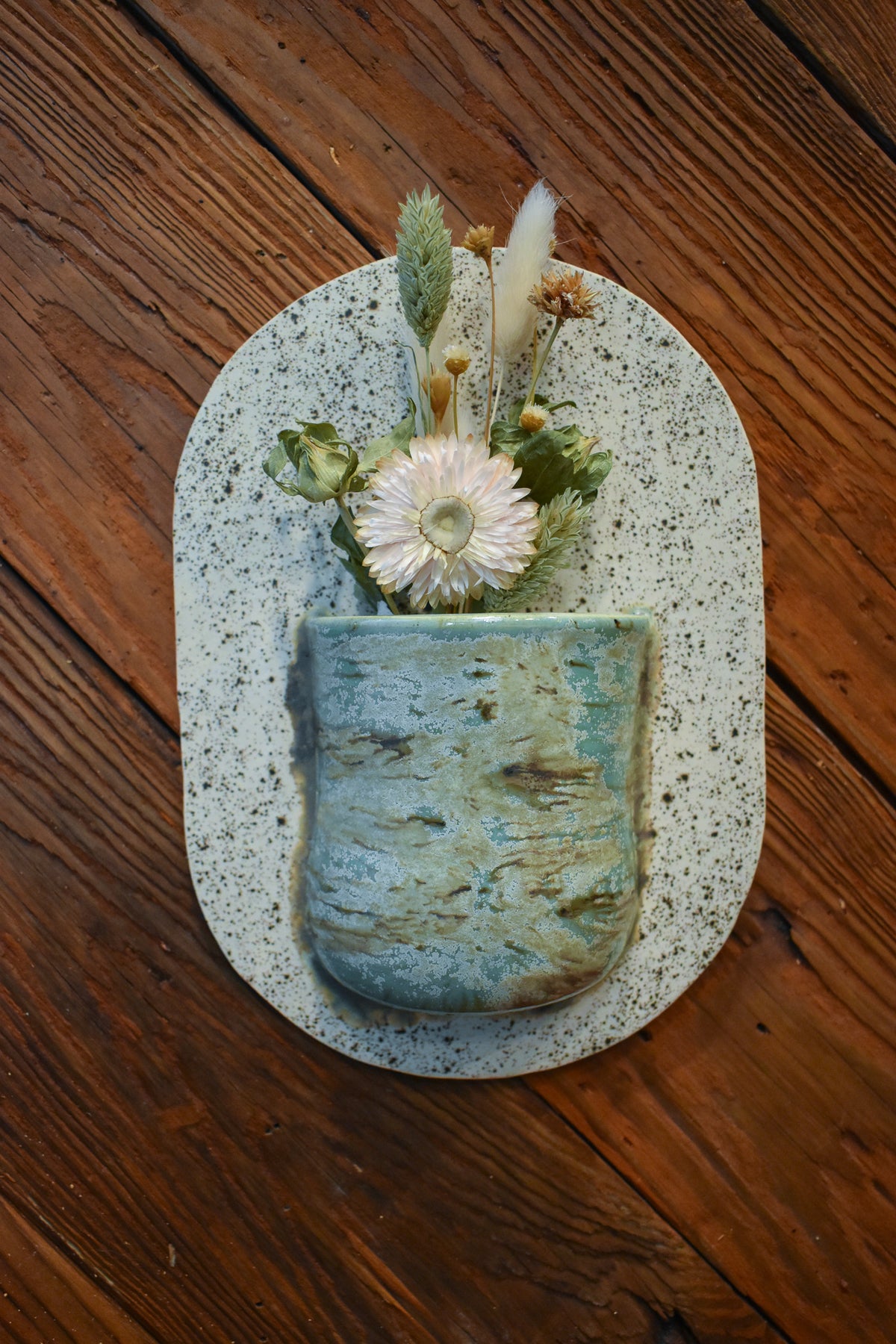 Large hand-formed wall vase in Sea Glass, an aqua sea-green bark-textured pocket on a speckled cream back plate