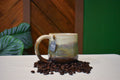 Hand-thrown mug in Autumn Hills, cream over olive and moss streaked with rust, settling to chocolate brown