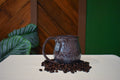 Hand-thrown mug carved with bark-like grain lines in Deep Plum, plum and burgundy glaze with a lavender-white rim