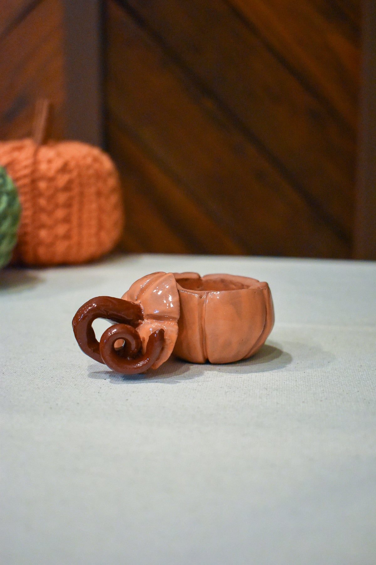 Hand-sculpted ceramic pumpkin jar with a lift-off lid, in glossy persimmon orange