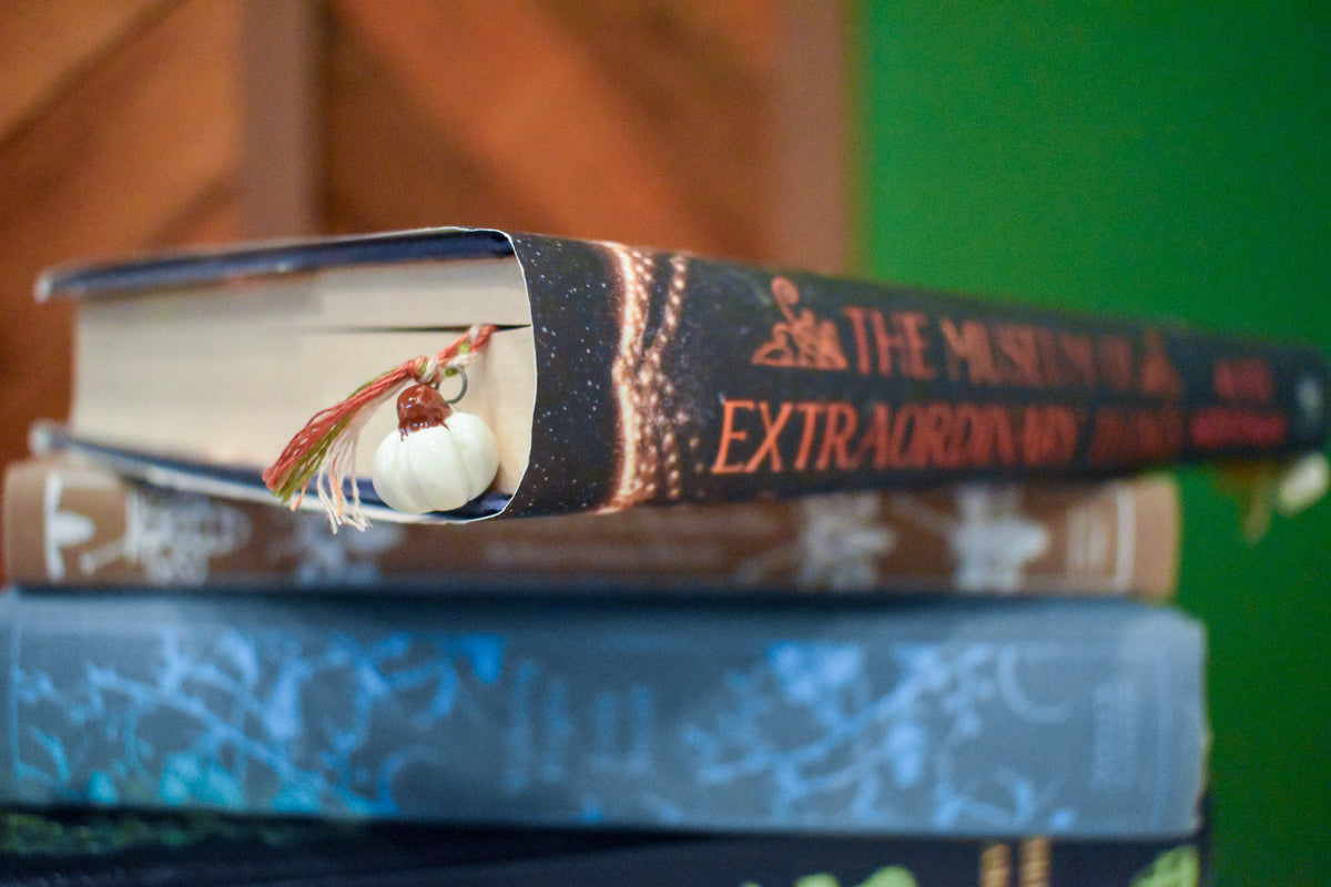 Hand-braided bookmark with hand-sculpted ceramic white pumpkins on a braided cord in red, orange, white, and green