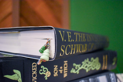 Hand-braided bookmark with hand-sculpted ceramic trees on a braided cord in green, blue, white, and brown