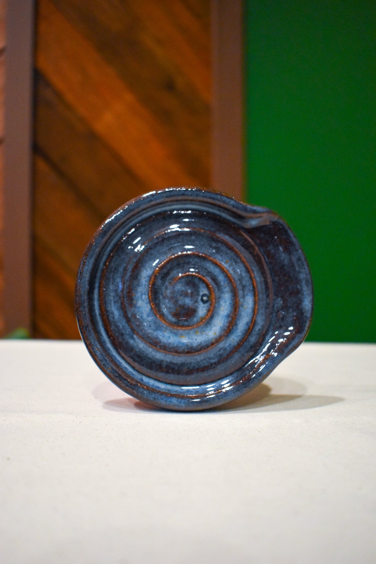 Hand-thrown spiral spoon rest in Tide Pool, deep blue with icy streaks