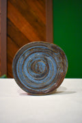 Hand-thrown spiral spoon rest in Stonewash, deep denim blue with a rust-brown rim