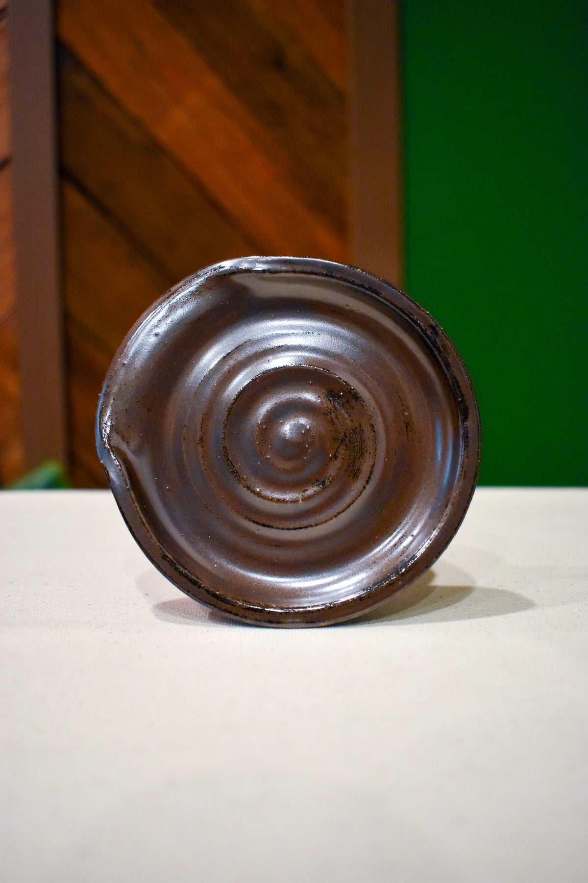 Hand-thrown spiral spoon rest in Walnut Husk, deep chocolate brown with rust speckle
