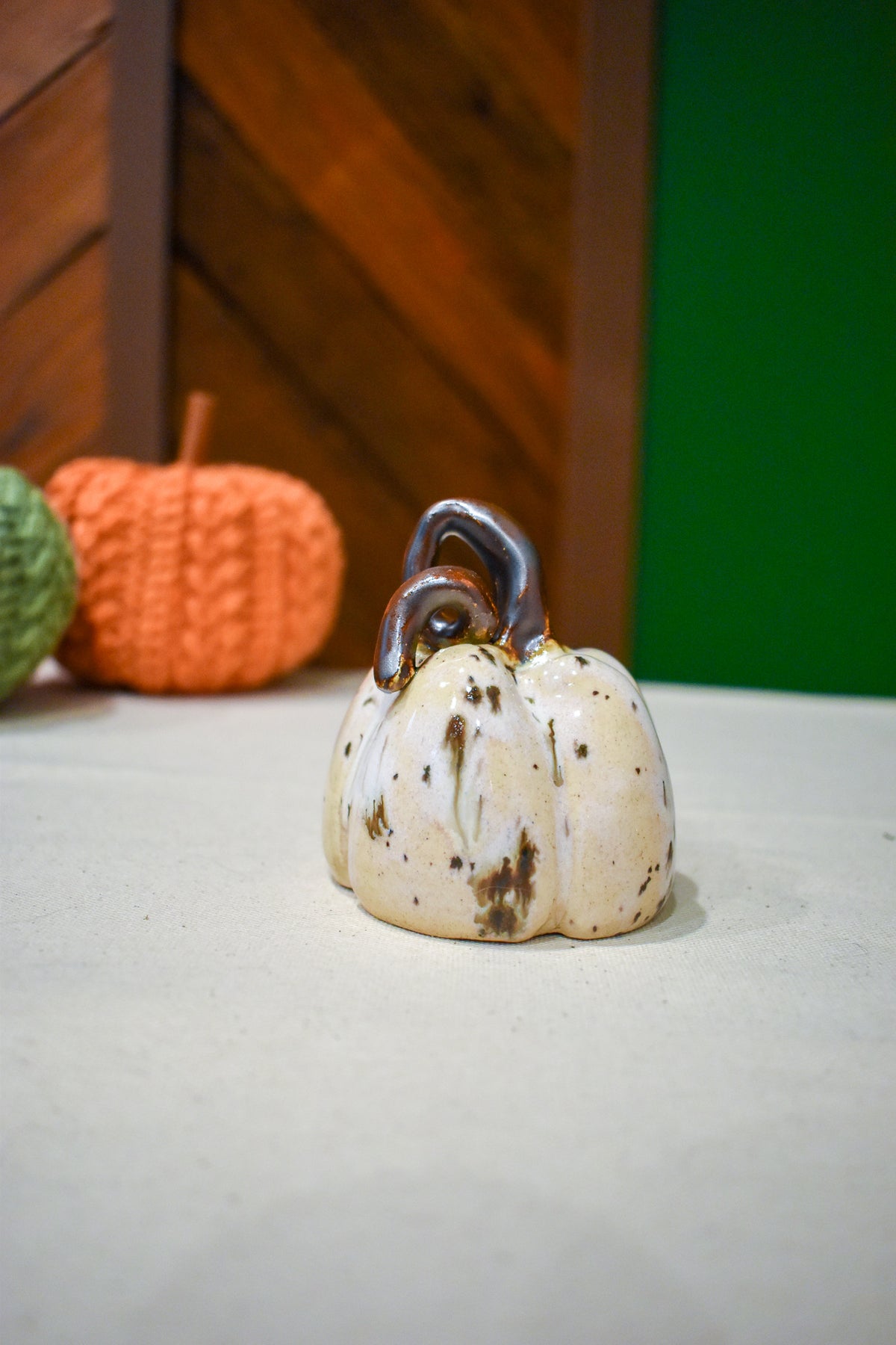 Hand-thrown ceramic pumpkin in a speckled vanilla-cream glaze with dark iron flecks