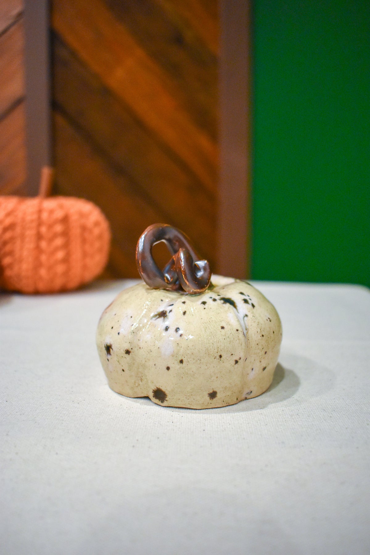 Hand-thrown ceramic pumpkin in a speckled vanilla-cream glaze with dark iron flecks