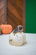 Hand-thrown ceramic pumpkin in a speckled vanilla-cream glaze with dark iron flecks