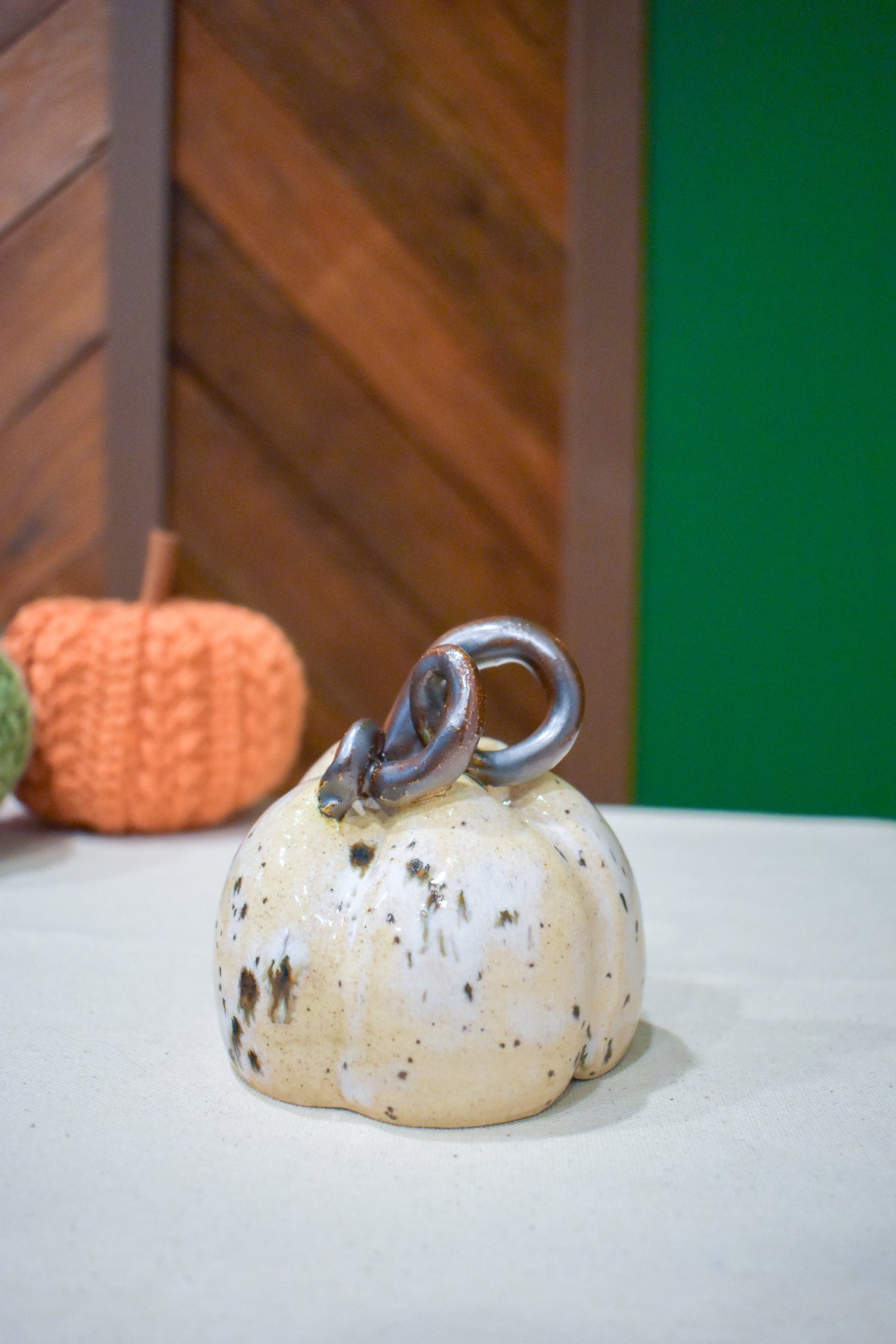 Hand-thrown ceramic pumpkin in a speckled vanilla-cream glaze with dark iron flecks