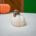 Hand-thrown ceramic pumpkin in creamy Whitewood glaze with a pewter-and-bronze vine