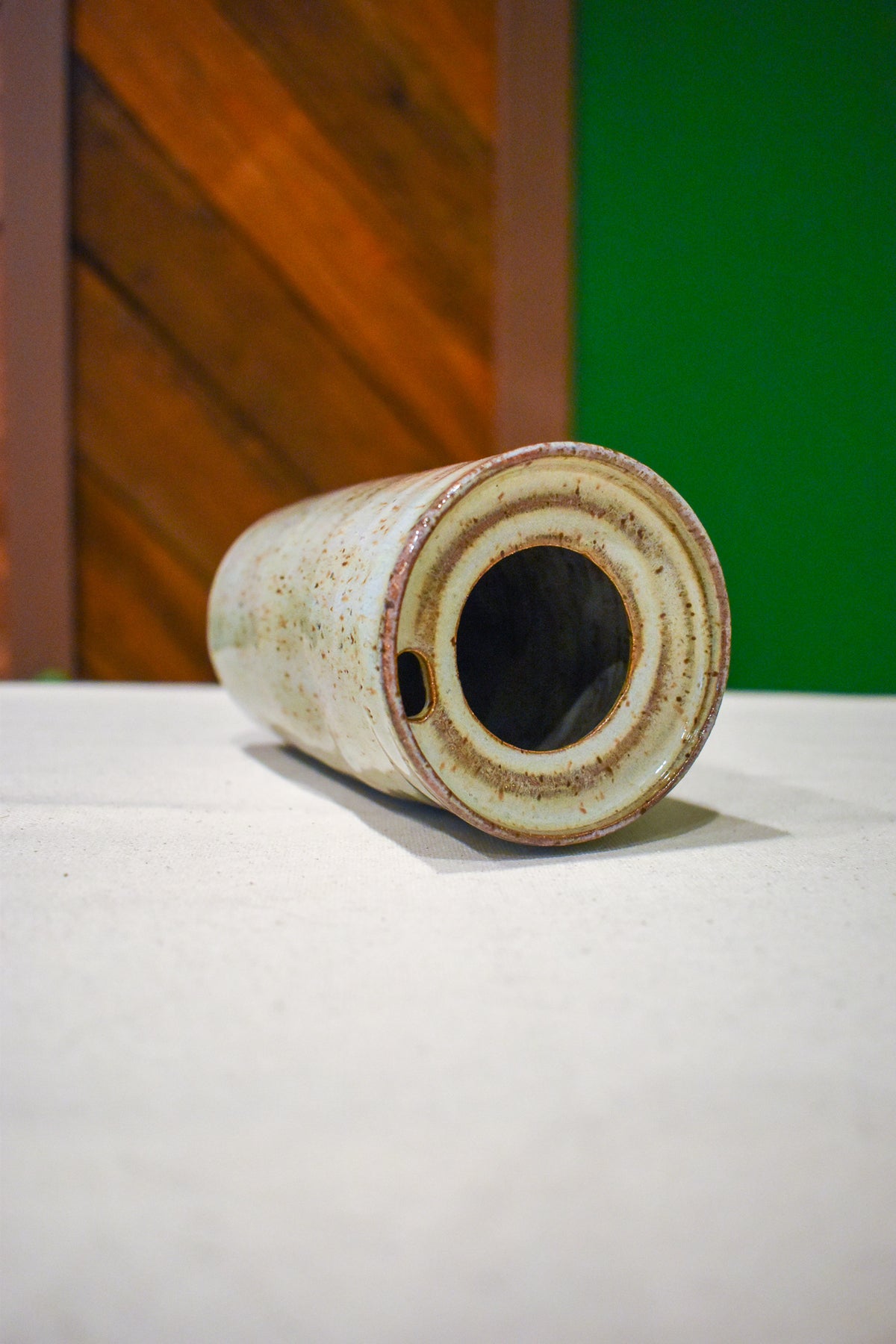 Hand-thrown ceramic travel mug in Linen, pale sage-gray and oatmeal with fine rust speckle
