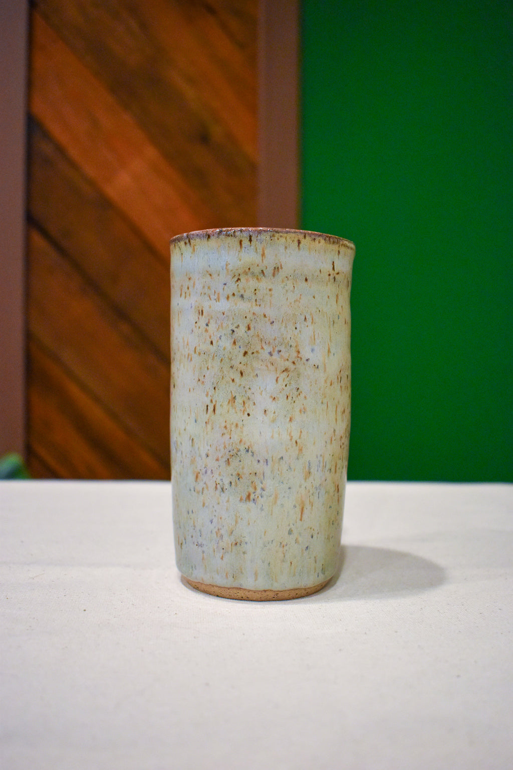 Hand-thrown ceramic travel mug in Linen, pale sage-gray and oatmeal with fine rust speckle