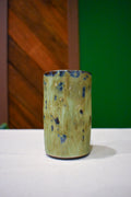Hand-thrown ceramic travel mug in River Moss, glossy moss green with deep blue flecks