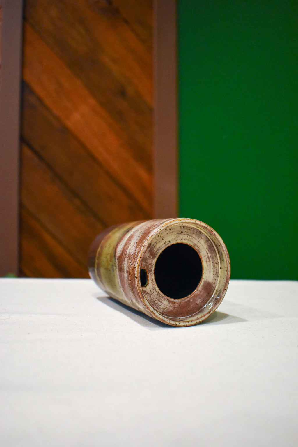 Hand-thrown ceramic travel mug in Autumn Hills, cream, olive, and chocolate brown