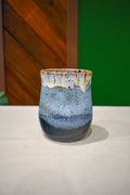 Hand-thrown handleless cup in Lakeshore, soft white drips over sky blue and slate navy
