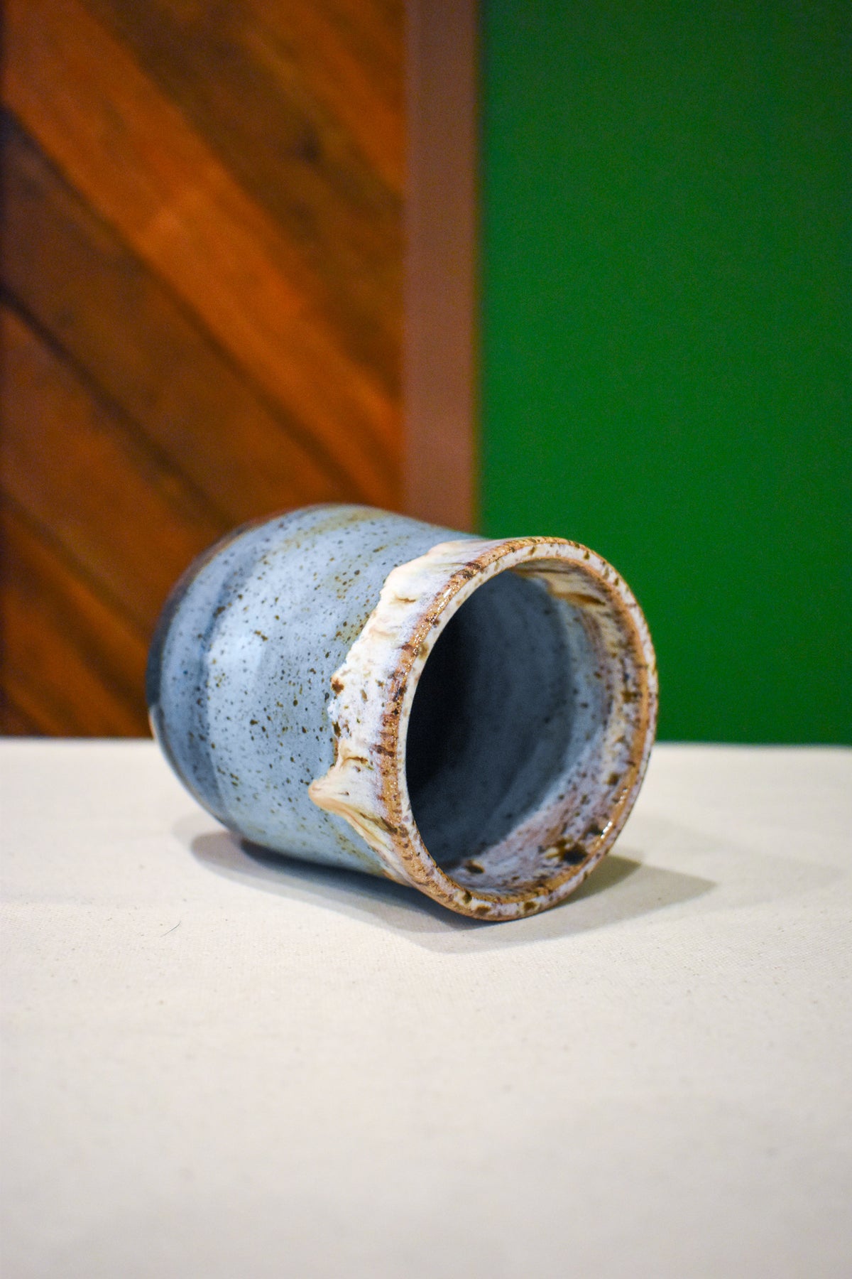 Hand-thrown handleless cup in Lakeshore, soft white drips over sky blue and slate navy