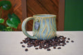 Hand-thrown mug carved with bark-like grain lines in Ivy, sage and soft blue-grey glaze with honey-gold highlights