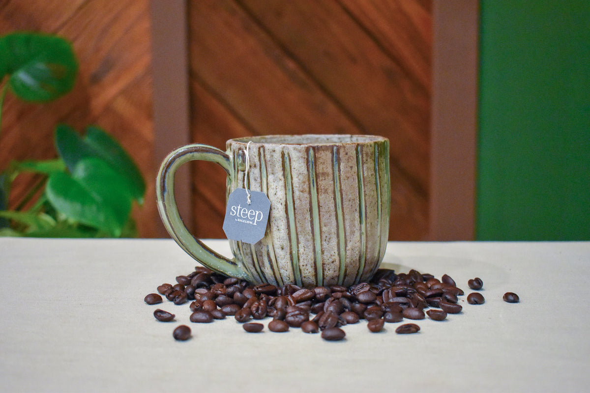 Hand-thrown mug with fine vertical carved lines in Linen Stripe, sage green in the grooves on a sandy clay body