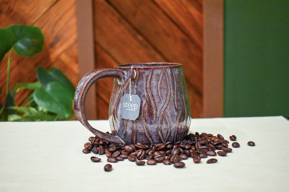 Hand-thrown mug carved with bark-like grain lines in Deep Plum, plum and burgundy glaze with a lavender-white rim