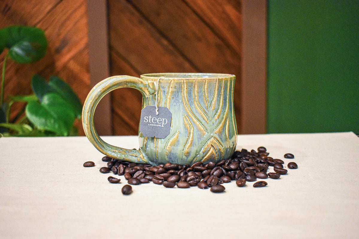 Hand-thrown mug carved with bark-like grain lines in Ivy, sage and soft blue-grey glaze with honey-gold highlights