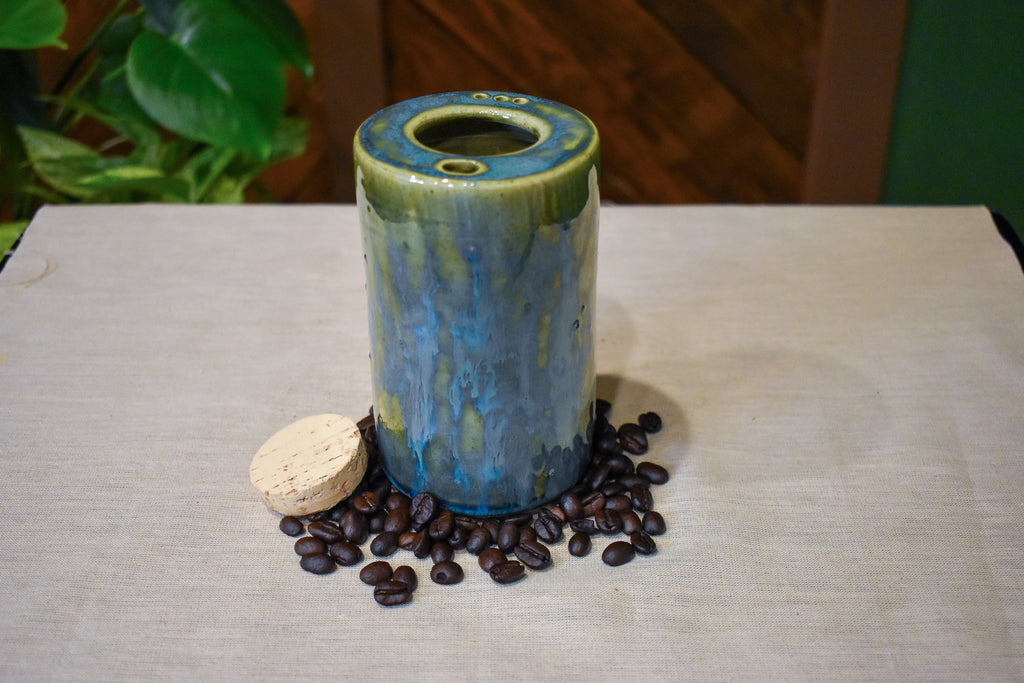Hand-thrown ceramic travel mug in Creekstone with a cork stopper, deep olive over mottled teal, slate blue and moss