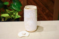 Hand-thrown vase in soft cream-white glaze with raised hand-carved snowflakes and a ceramic lid