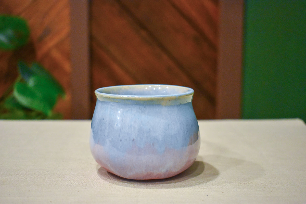 Small hand-thrown cup in Blush Bloom, petal pink rising from the base through lavender to frosted blue at the rim