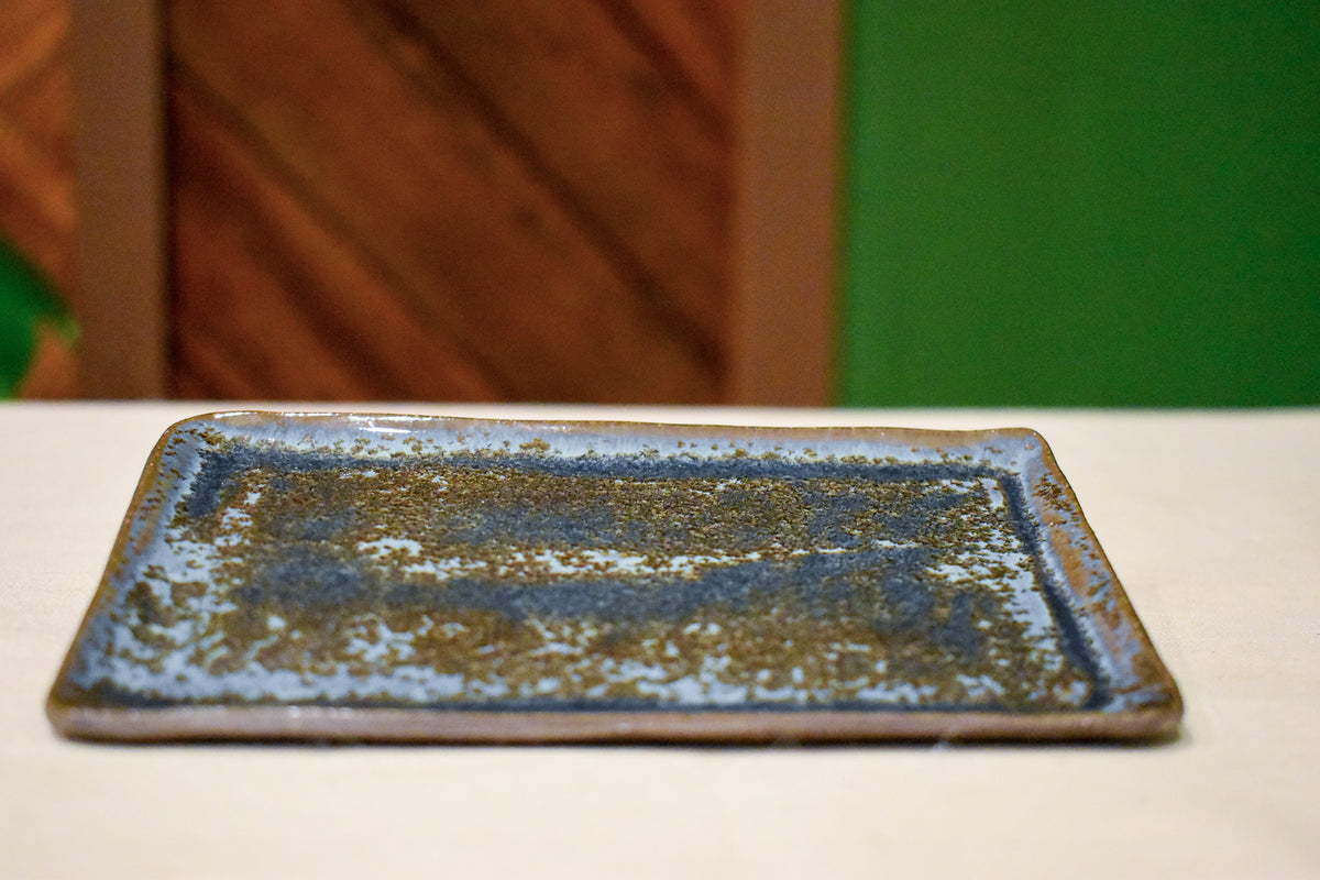 Hand-formed long rectangular catch-all dish in Tide & Earth, deep teal-blue glaze with warm iron speckling