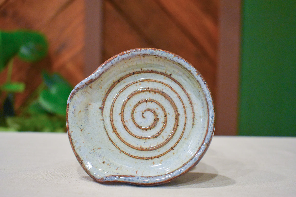 Hand-thrown spiral spoon rest in Linen, cream and warm oatmeal with a deep iron-rust spiral and rim