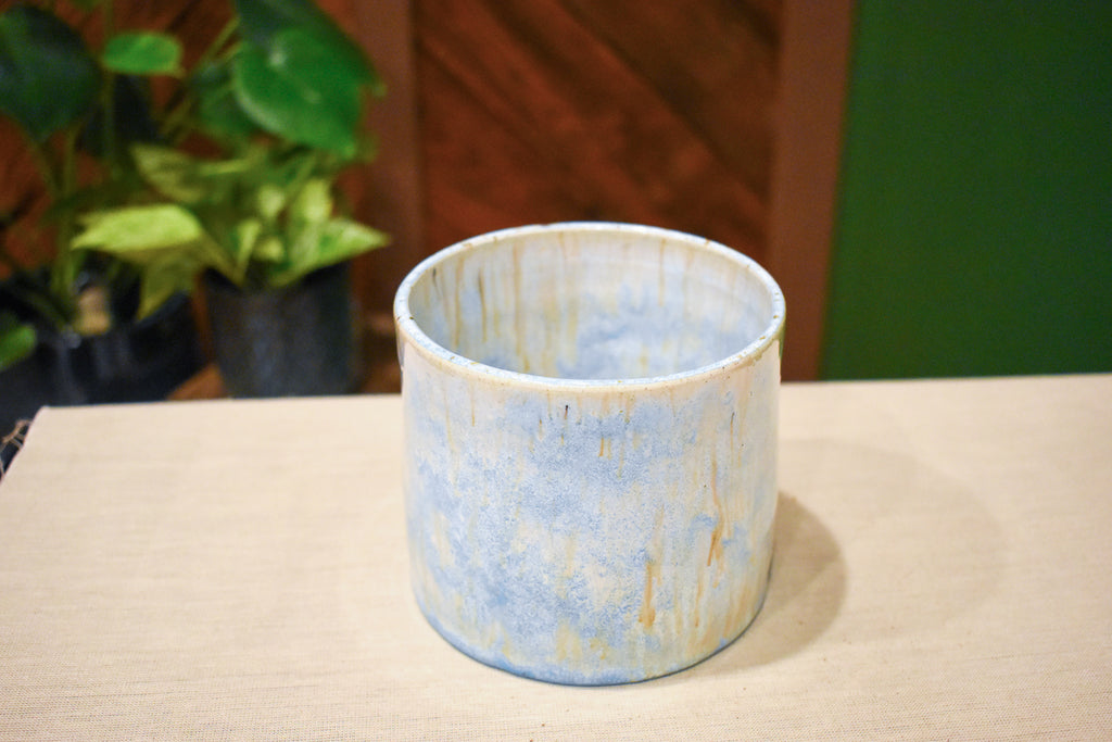 Hand-thrown open-form vase in Morning Rain, pale blue matte glaze with warm tan drips from the rim