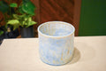 Hand-thrown open-form vase in Morning Rain, pale blue matte glaze with warm tan drips from the rim