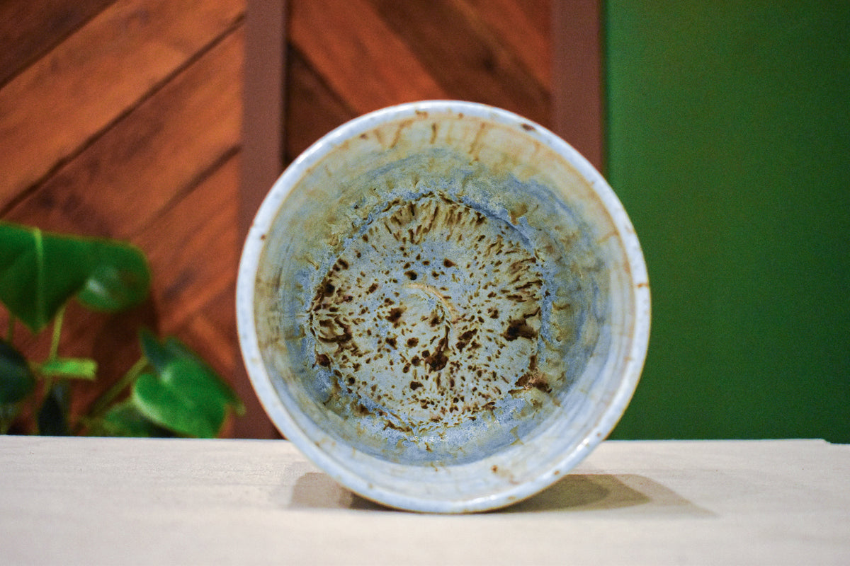 Hand-thrown open-form vase in Morning Rain, pale blue matte glaze with warm tan drips from the rim