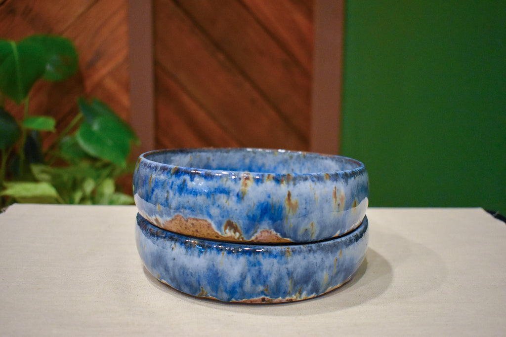 Pair of hand-thrown tall-walled plates (blates) in Coastal Hollow, cobalt blue glaze with warm rust-amber breaks