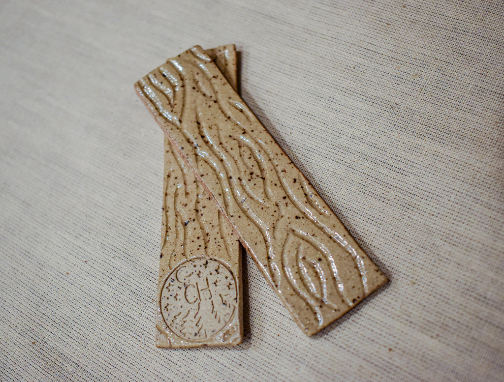 Hand-formed stoneware bookmark in Woodgrain, bare speckled clay with carved wood-grain lines glazed clear