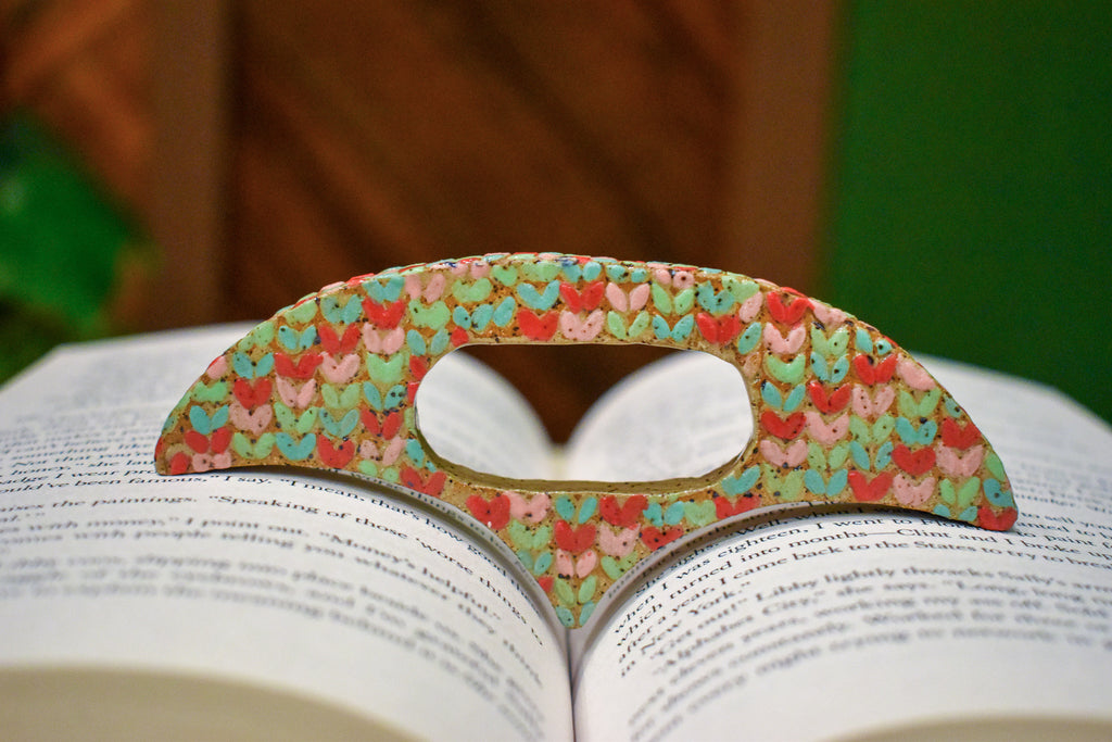 Hand-formed ceramic thumb book holder in Sherbet Knit, knit-stitch texture in mint, coral and soft pink