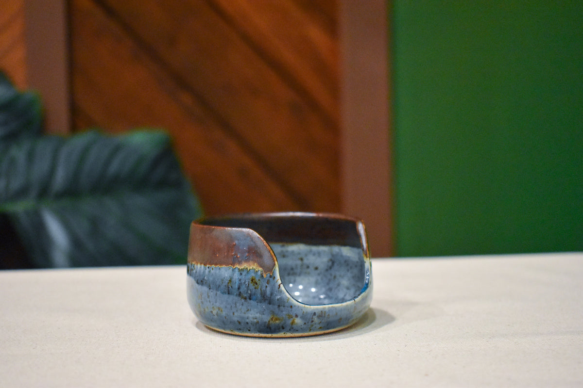 Small upright hand-thrown spoon rest in Iron Blue, slate blue with speckle and a rust rim, with a notch for the spoon handle