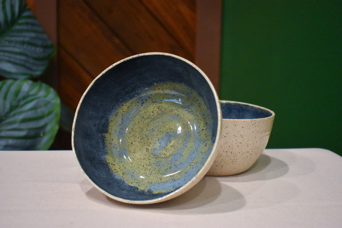 Hand-thrown bowl in Rock Pool, speckled oatmeal cream outside and deep slate blue inside with a swirl of olive and gold