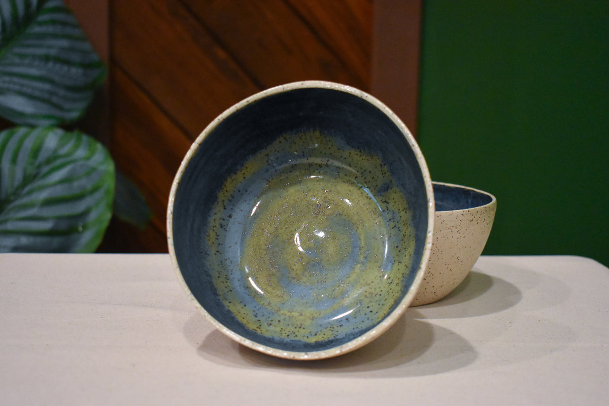 Hand-thrown bowl in Rock Pool, speckled oatmeal cream outside and deep slate blue inside with a swirl of olive and gold