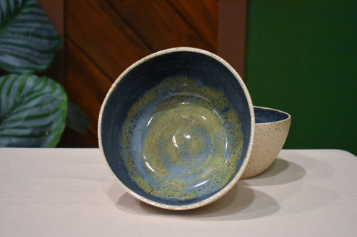 Hand-thrown bowl in Rock Pool, speckled oatmeal cream outside and deep slate blue inside with a swirl of olive and gold