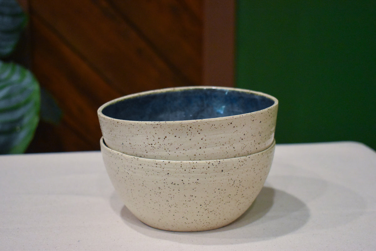 Hand-thrown bowl in Rock Pool, speckled oatmeal cream outside and deep slate blue inside with a swirl of olive and gold