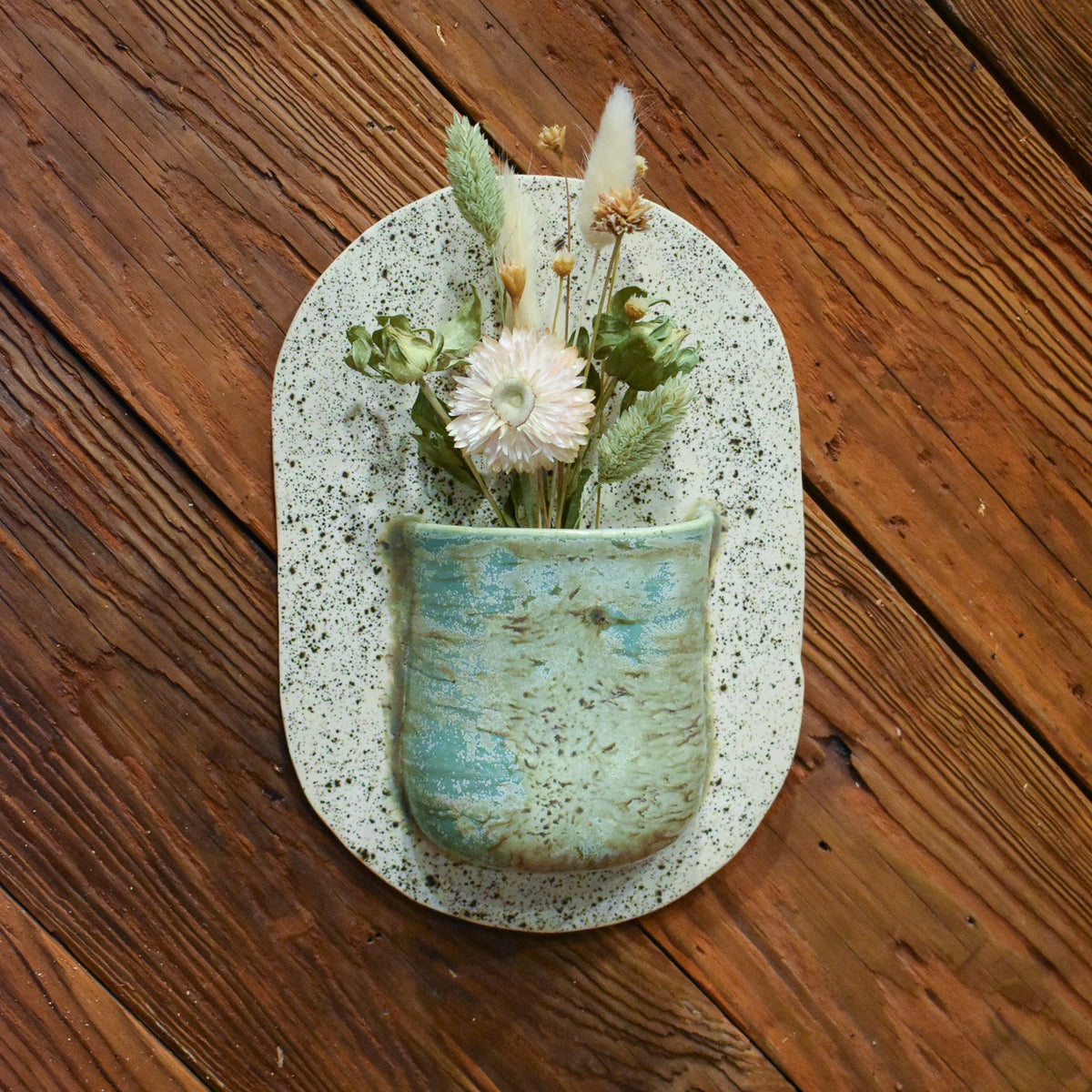 Large hand-formed wall vase in Sea Glass, an aqua sea-green bark-textured pocket on a speckled cream back plate