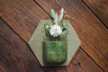 Medium hand-formed wall vase in Woodland, a glossy forest-green pocket on an oatmeal hexagon back plate
