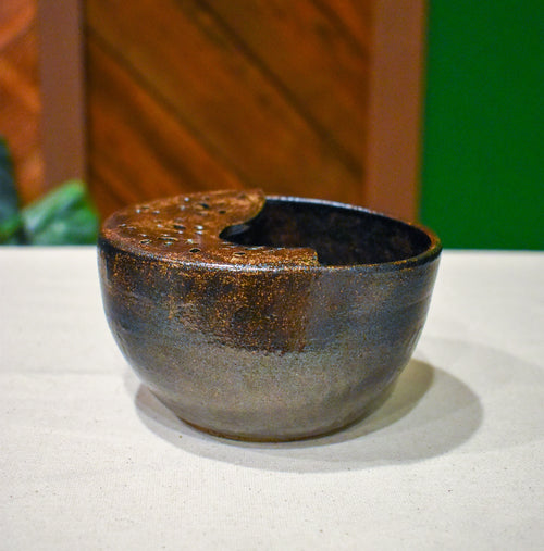 Hand-thrown ceramic berry bowl with a hand-punched drain panel, in glittering near-black Cosmic Tea Dust