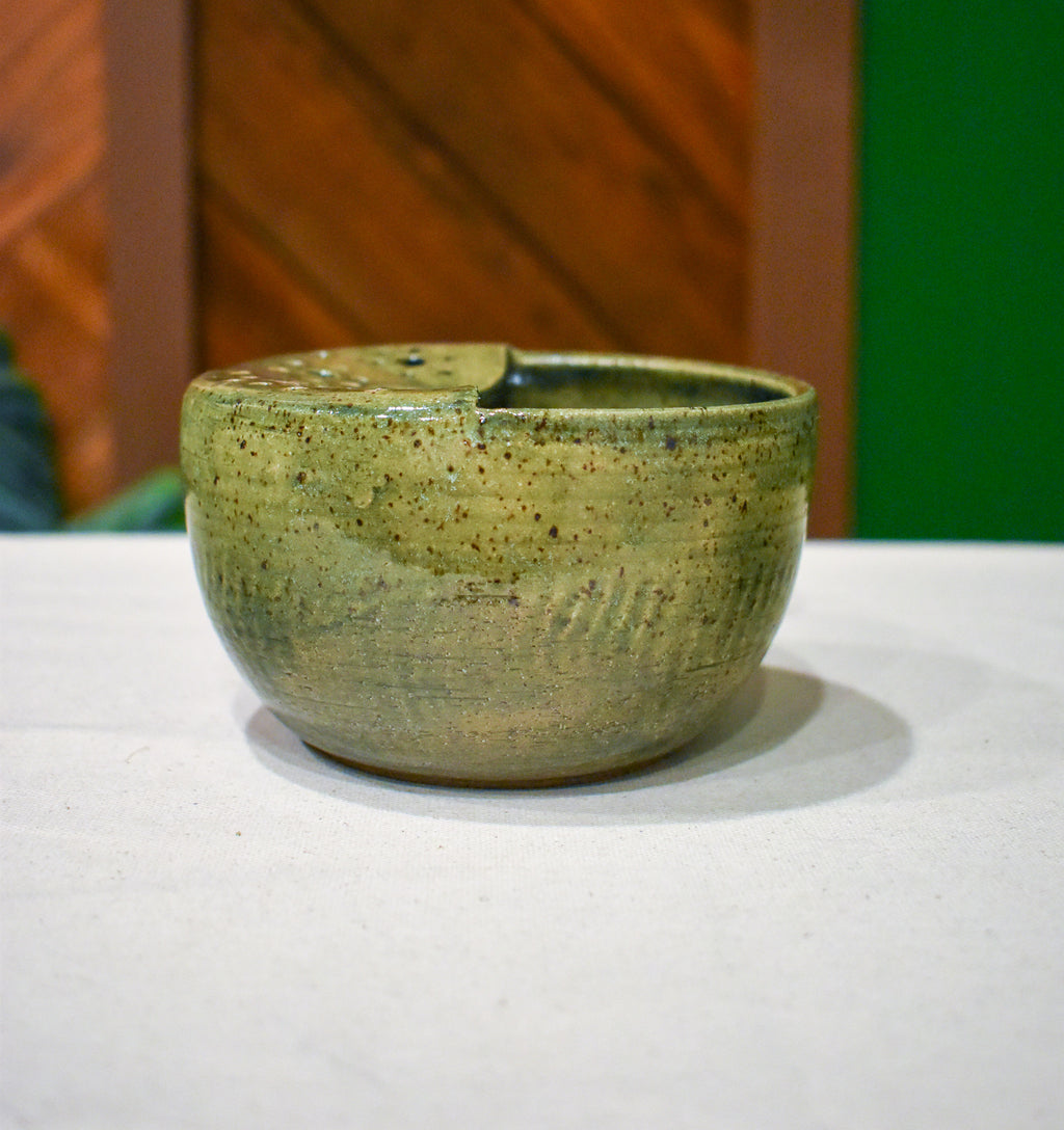 Hand-thrown ceramic berry bowl with a hand-punched drain panel, in moss-green Canopy