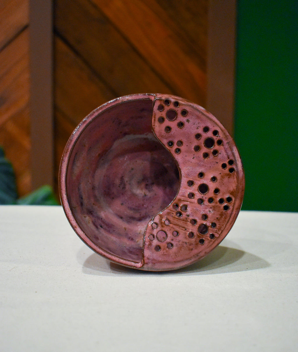 Hand-thrown ceramic berry bowl with a hand-punched drain panel, in rose-pink Mulberry