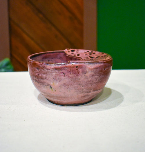 Hand-thrown ceramic berry bowl with a hand-punched drain panel, in rose-pink Mulberry